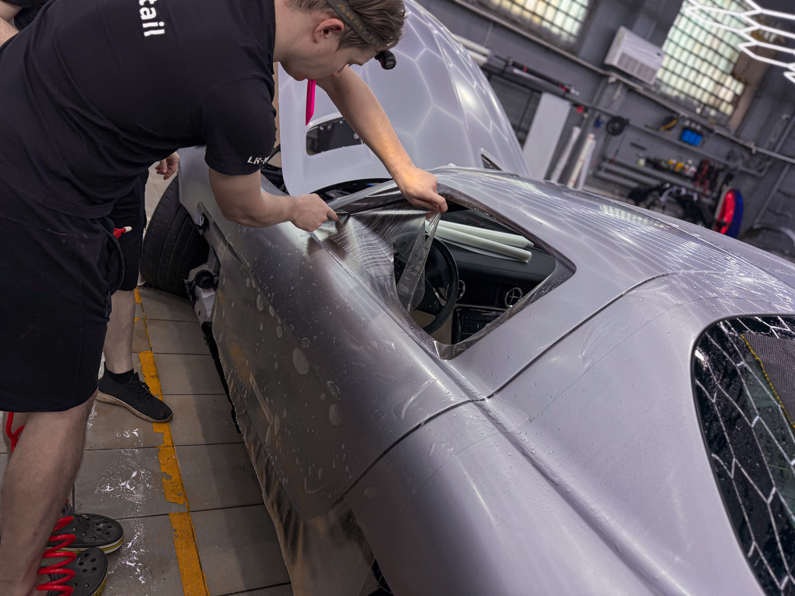 мастер оклеивает сложный кузовной элемент Mercedes-AMG SLS