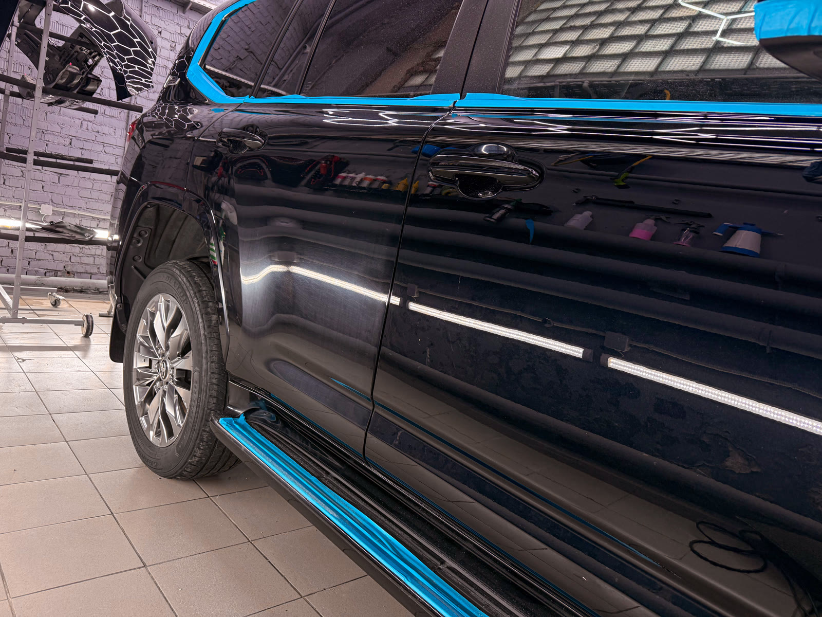 боковая часть Toyota Land Cruiser 300 в процессе полировки кузова