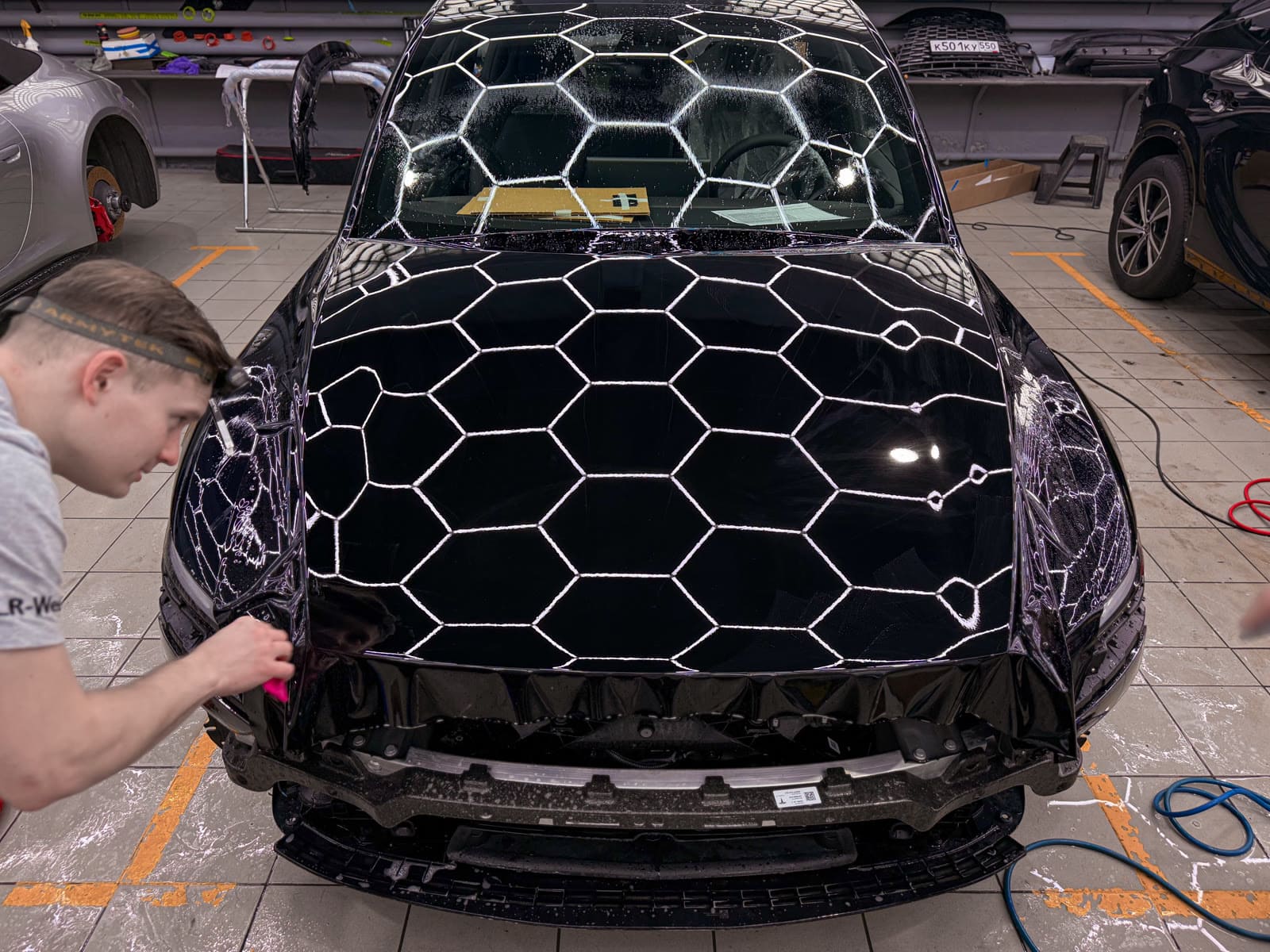Защита Tesla Model Y чёрным полиуретаном — в процессе защиты глянцевых элементов, кадр 1