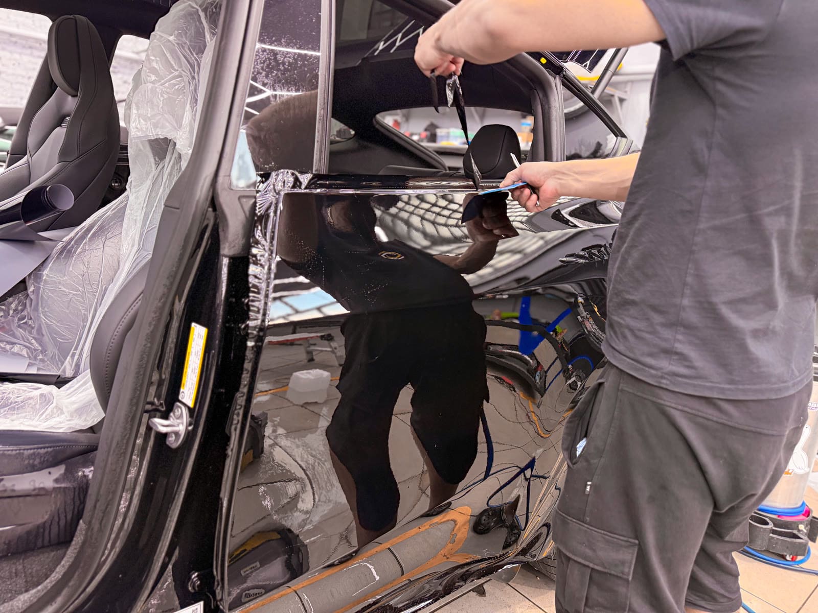 Защита Tesla Model Y чёрным полиуретаном — в процессе защиты глянцевых элементов, кадр 5